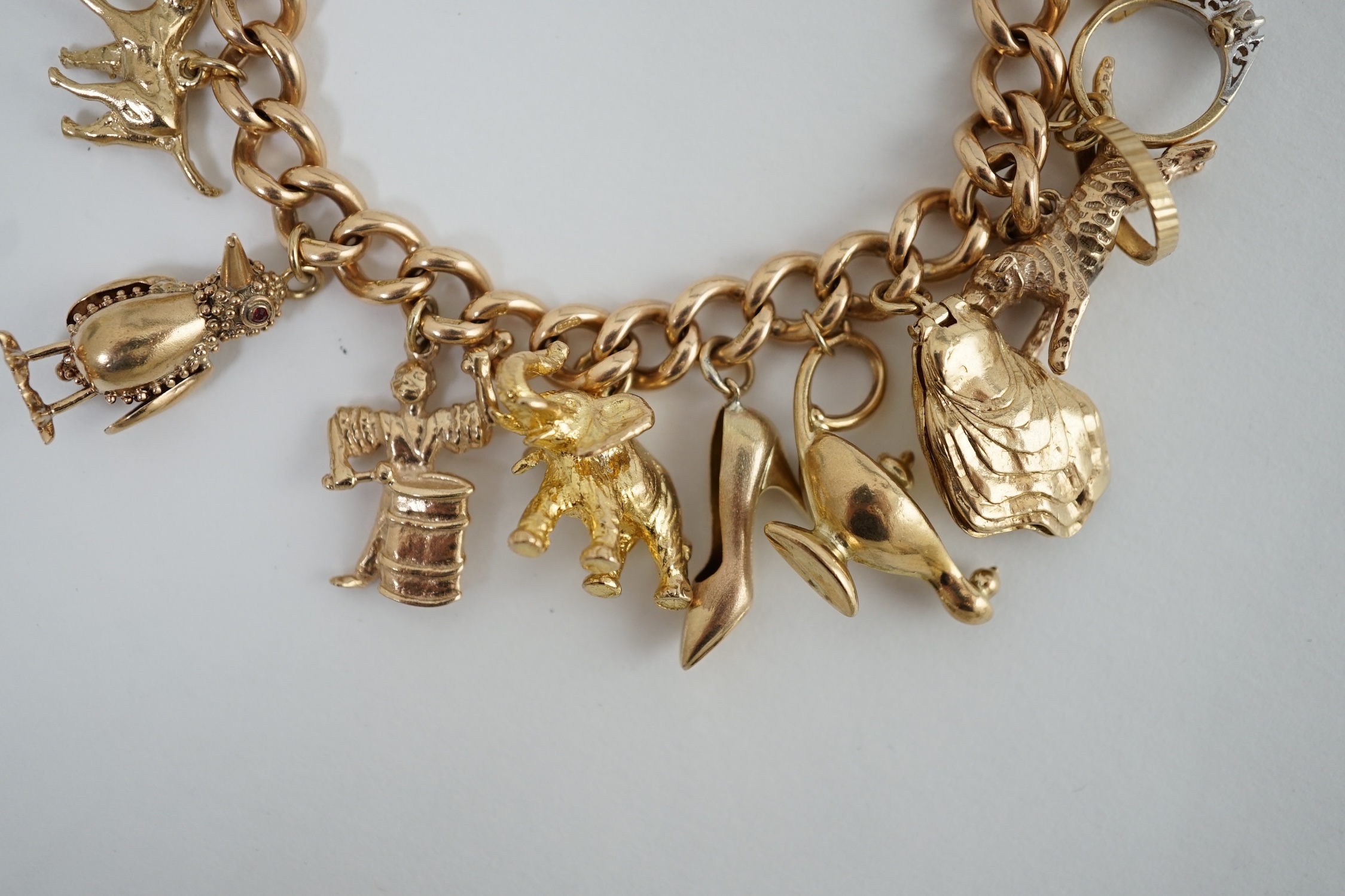 An early 20th century 15ct gold curb link charm bracelet